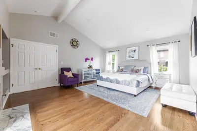 a bedroom with a white bed and a purple chair at Tranquil family beach city retreat in Redondo Beach