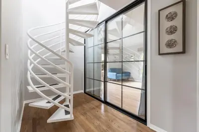a white spiral staircase in a living room with a window at Tranquil family beach city retreat in Redondo Beach
