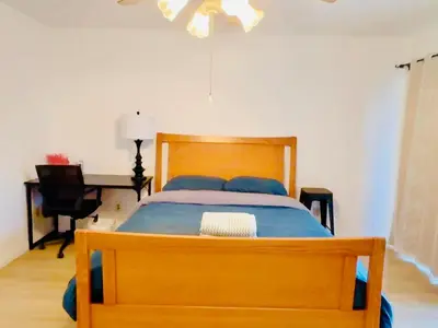 a bedroom with a wooden bed and a desk at 1b1b Private and quiet sun roomA in Rancho Cucamonga