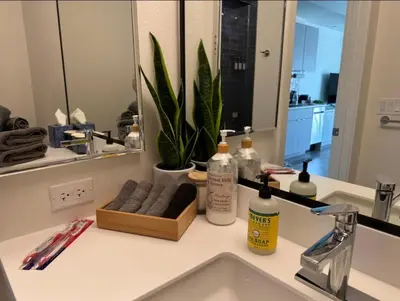 a bathroom sink with two bottles of soap and a mirror at Heart of Hollywood-Walk of Fame 1bd Studio with View -Free parking, balcony, wifi, rooftop, gym, upscale amenities in Los Angeles
