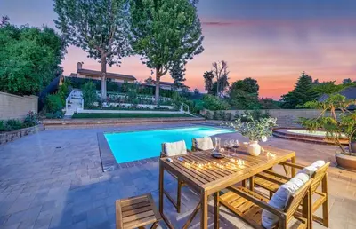 a patio with a table and chairs next to a swimming pool at Luxe Sundance Villa 3BR with Pool and Spa Near Disney in Pomona