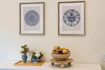 a table with a bowl of fruit and two pictures on the wall at Luxe Sundance Villa 3BR with Pool and Spa Near Disney in Pomona
