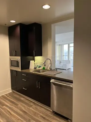a kitchen with black cabinets and a stainless steel sink at HollywoodNorth in Los Angeles