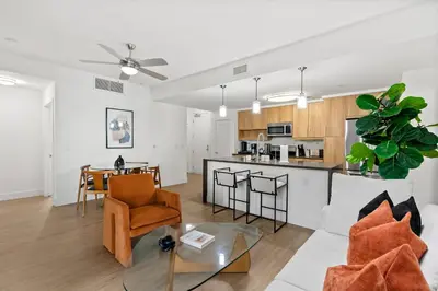 an open living room and kitchen with a table and chairs at Amethyst Horizon - Stylish peaceful 2BR w zen Garden View Pool Gym in Los Angeles