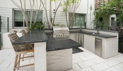 a outdoor kitchen with a counter and a grill at Amethyst Horizon - Stylish peaceful 2BR w zen Garden View Pool Gym in Los Angeles