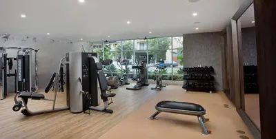 a gym with several treadmills and exercise equipment in a room at Amethyst Horizon - Stylish peaceful 2BR w zen Garden View Pool Gym in Los Angeles
