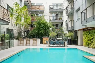 an apartment patio with a swimming pool and a table and chairs at Amethyst Horizon - Stylish peaceful 2BR w zen Garden View Pool Gym in Los Angeles