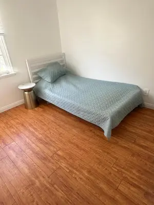 a small bed in a room with a wooden floor at Cute room in best area of Hollywood in Los Angeles