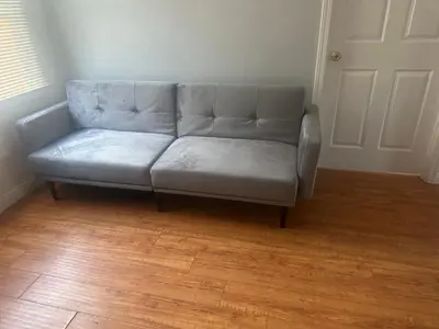 a couch in a living room with a wooden floor at Cute room in best area of Hollywood in Los Angeles