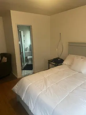 a bedroom with a white bed and a bathroom at Sofi Intuit Forum Vacation Oasis in Los Angeles