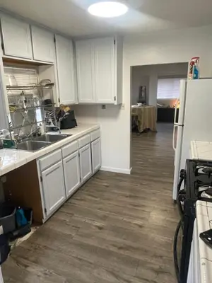 a kitchen with white cabinets and a kitchen floor at Sofi Intuit Forum Vacation Oasis in Los Angeles