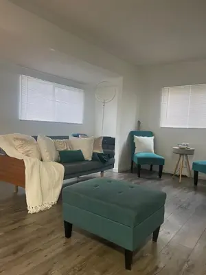 a living room with a couch and a table and chairs at Sofi Intuit Forum Vacation Oasis in Los Angeles