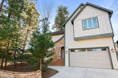 a brick house with a garage and trees at NEW Serenity Lodge Base Of Snow Summit Hot Tub in Big Bear Lake