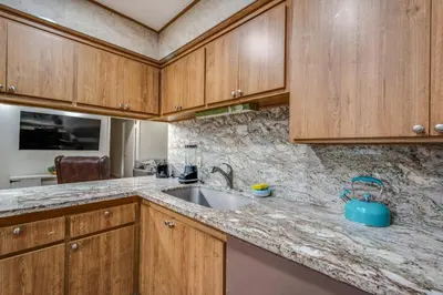 a kitchen with wooden cabinets and a sink at Newly Renovated Home Spacious Close 2 Hospital in San Bernardino