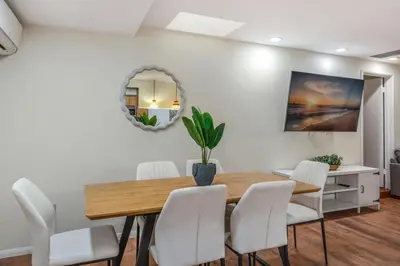 a dining room with a wooden table and white chairs at Newly Renovated Home Spacious Close 2 Hospital in San Bernardino