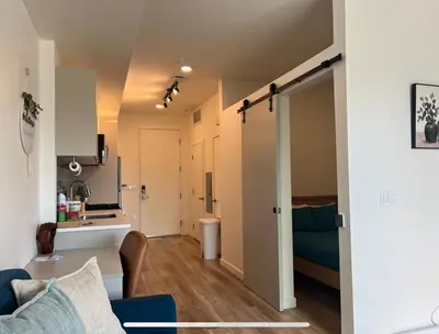 a living room with a blue couch and a kitchen at Modern Hollywood Walk of Fame Apts- Free Parking, 360 Rooftop, Pool, Gym- Centrally located in Los Angeles