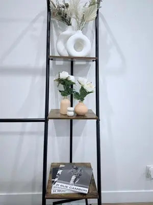 a shelf with vases and flowers and a magazine at Modern Family Haven - Minutes from Disney Magic-OC in Midway City