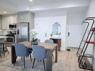 a kitchen and dining room with a table and chairs at Modern Family Haven - Minutes from Disney Magic-OC in Midway City
