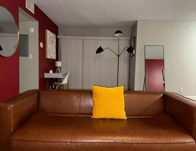 a brown leather couch with a yellow pillow on it at Beverly Hills Charm Rodeo Cedar in Los Angeles