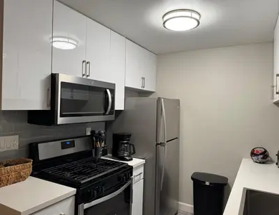 a kitchen with a stove and a stainless steel refrigerator at Beverly Hills Charm Rodeo Cedar in Los Angeles