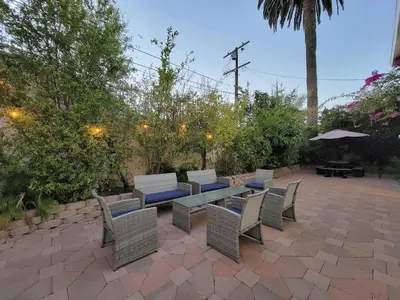 a patio with a table and chairs and an umbrella at 3 bedroom guest suite first floor unit with nice patio area right next to the MrC Hotel 10 minutes from Rodeo Drive Washer Dryer WIFI and more in Los Angeles