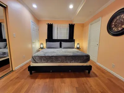 a bedroom with a bed and a large clock on the wall at 3 bedroom guest suite first floor unit with nice patio area right next to the MrC Hotel 10 minutes from Rodeo Drive Washer Dryer WIFI and more in Los Angeles