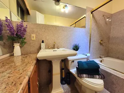 a bathroom with a sink and a toilet and a mirror at 3 bedroom guest suite first floor unit with nice patio area right next to the MrC Hotel 10 minutes from Rodeo Drive Washer Dryer WIFI and more in Los Angeles