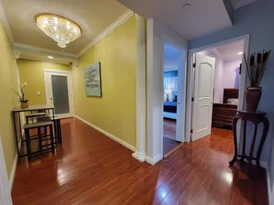 a living room with a hard wood floor and yellow walls at 3 bedroom guest suite first floor unit with nice patio area right next to the MrC Hotel 10 minutes from Rodeo Drive Washer Dryer WIFI and more in Los Angeles