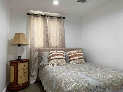 a bedroom with a bed and a lamp on a night stand at Serene Sherman Oaks Cottage with Outdoor Space in Los Angeles