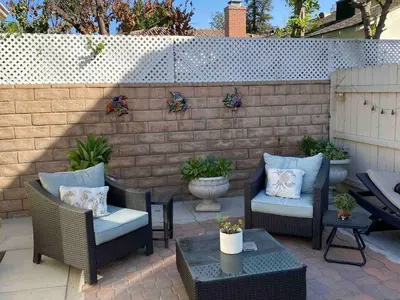 a patio with chairs and tables and a brick wall at Serene Sherman Oaks Cottage with Outdoor Space in Los Angeles
