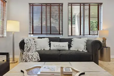 a living room with a black couch and windows at Los Angeles Large Mediteranian Vacation Home in Sherman Oaks Community Hospital Heliport