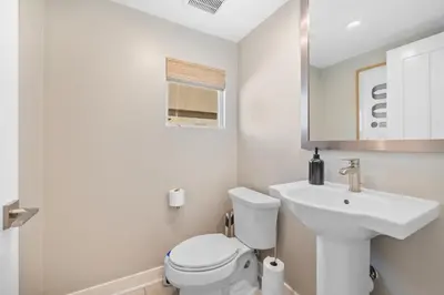 a white bathroom with a toilet and a sink at #Marbella Lane-Luxury Designer 3BR Home Disneyland in Anaheim