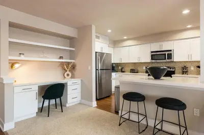 a kitchen with white cabinets and black stools at The Citrine Suite - Water View Large Condo 2BR Marina in Los Angeles