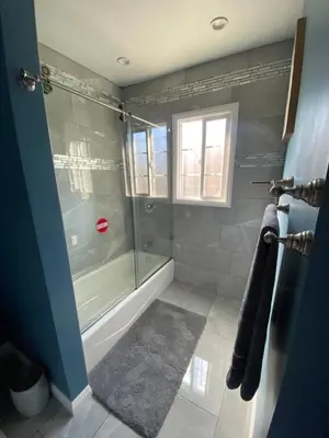 a bathroom with a shower and a tub and a window at Faith House in Los Angeles