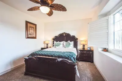 a bedroom with a large bed and a ceiling fan at Peaceful Oasis in Anaheim