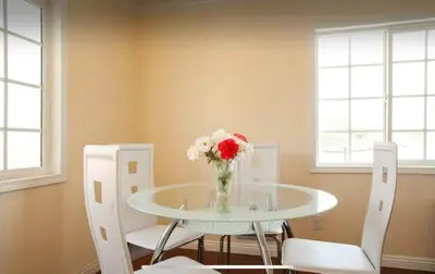 a vase of flowers on a glass table with two chairs at 3 bedroom apartment by the MrC Hotel and 5 minutes to Rodeo Drive WiFi TV Patio walk to restaurants in Los Angeles