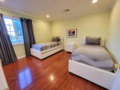a bedroom with two beds and a wooden floor at 3 bedroom apartment by the MrC Hotel and 5 minutes to Rodeo Drive WiFi TV Patio walk to restaurants in Los Angeles