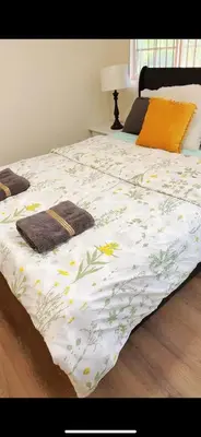 a bed with a white comforter with flowers on it at Pretty bedroom private bathroom in Hacienda Heights