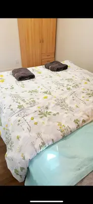 a bed with a white blanket with flowers on it at Pretty bedroom private bathroom in Hacienda Heights