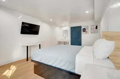 a white bedroom with a bed and a desk at Casablanca Inn in Bell