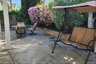 a patio with two chairs and an umbrella at Travelers Mini Stays - Revelation Nation Welcome in Simi Valley