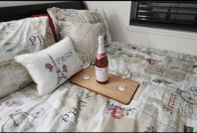 a bottle of wine and glasses on a bed at Travelers Mini Stays - Revelation Nation Welcome in Simi Valley