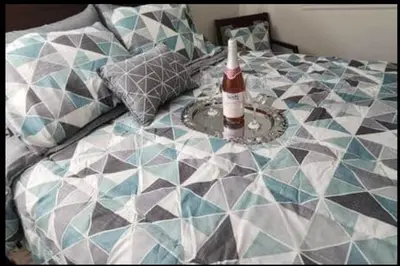 a bed with a bottle of alcohol on it at Travelers Mini Stays - Revelation Nation Welcome in Simi Valley
