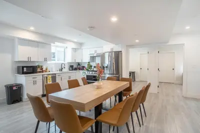 a kitchen and dining room with a wooden table and chairs at Cozy Urban Retreat near Downtown LA & USC - Private room with shared Living room and kitchen in Los Angeles