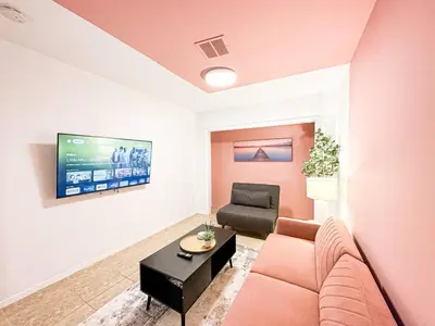 a living room with a couch and a tv on a wall at Cozy 1-BR Poolside Getaway in West LA - LOU2 - WW in Los Angeles