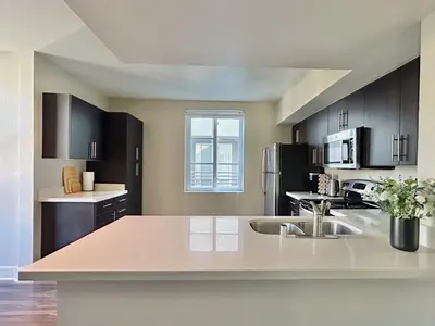 a kitchen with black cabinets and a counter top at 2BD 2BA Santa Monica Apartment with Relaxing Pool View in Los Angeles