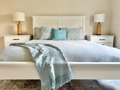 a bedroom with a white bed with a blanket on it at 2BD 2BA Santa Monica Apartment with Relaxing Pool View in Los Angeles