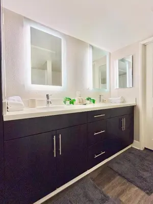a bathroom with two sinks and two mirrors at 2BD 2BA Santa Monica Apartment with Relaxing Pool View in Los Angeles