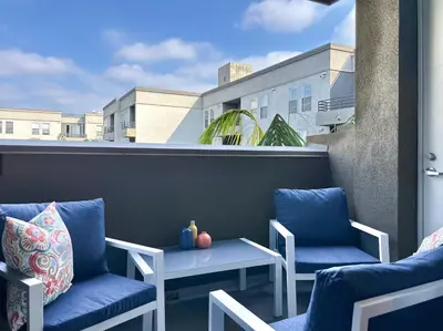 two chairs and a table on a balcony at 2BD 2BA Santa Monica Apartment with Relaxing Pool View in Los Angeles