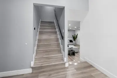 a staircase in a house with white walls and wooden floors at Spacious 4-bedroom Glendora Super House in Glendora